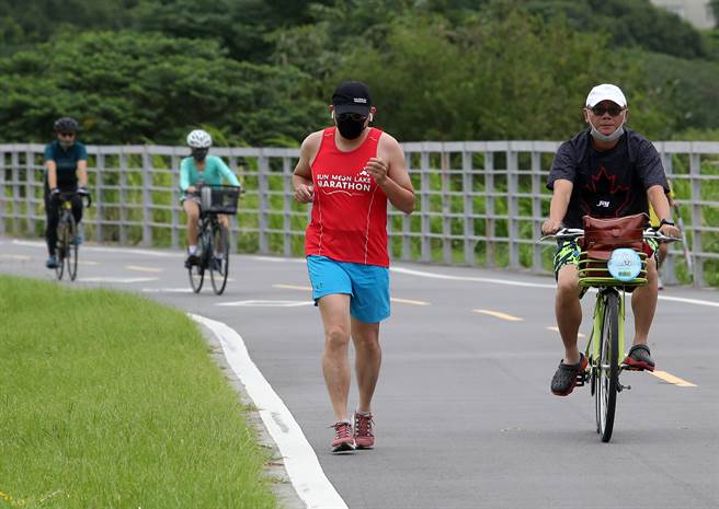 指挥中心中今天宣布10月19日起放宽民眾户外运动时，可免戴口罩，但休息时仍需戴上，图为民眾戴口罩运动。（刘宗龙摄）