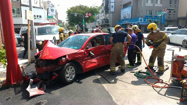 红色自小客车发生车祸后，车上4人受困，消防人员利用破坏器材打开车门。（读者提供／洪荣志台南传真）