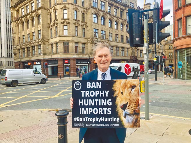 英國保守黨資深國會議員顏敏時（David Amess）15日遭一名持刀男子連刺數刀，傷重身亡。顏敏時是動物愛好者，圖為他在街頭舉牌，宣傳禁止「戰利品狩獵」（trophy hunting）。（摘自顏敏時推特）