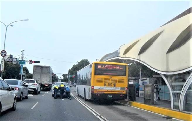 一輛汽車故障卡在台灣大道上，員警與民眾徒手將車子推至路邊助脫困。（民眾提供／盧金足台中傳真）