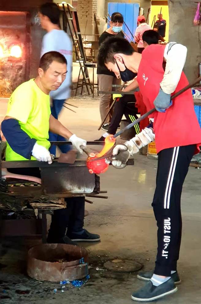 师傅们利用煅烧后琉璃的流动性，将琉璃塑形。（蓝孝威摄）