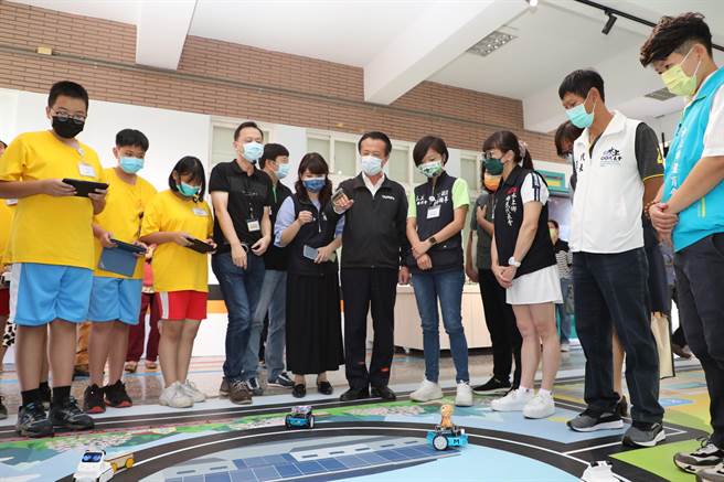 嘉義縣長翁章梁等人在嘉義縣觀光地圖的地板上，體驗操作AI智慧車。（呂妍庭攝）