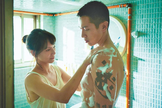 李心洁（左）在《鱷鱼》中帮受伤的柯震东洗澡。（myVideo、双喜电影提供）