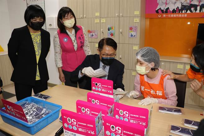 新北市副市長陳純敬（中）和央北社宅身障小作所學員一起將口罩裝入盒中，左為社會局長張錦麗和市議員陳儀君。（葉書宏攝）