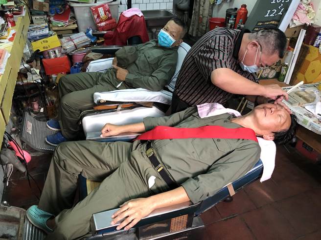 昔日戍守前线的老战友重返金门，相揪走进特约商店理髮，回忆当年军旅点滴往事。（李金生摄）