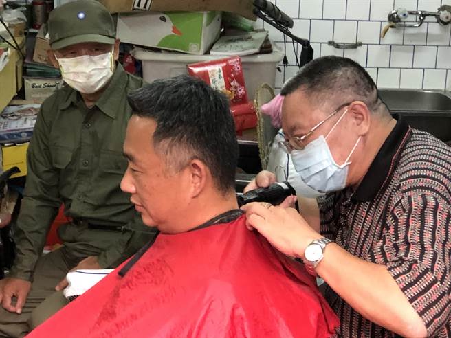 杨镇浯县长今天也穿上草绿服，与老军友一起体验传统理髮店才有的乐趣。（李金生摄）