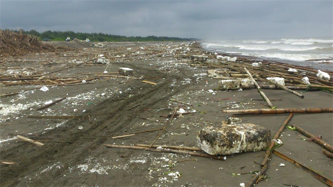 颱风过后被摧毁的旧式蚵棚被冲至海岸造成污染。（台南市政府提供／张毓翎台南传真）