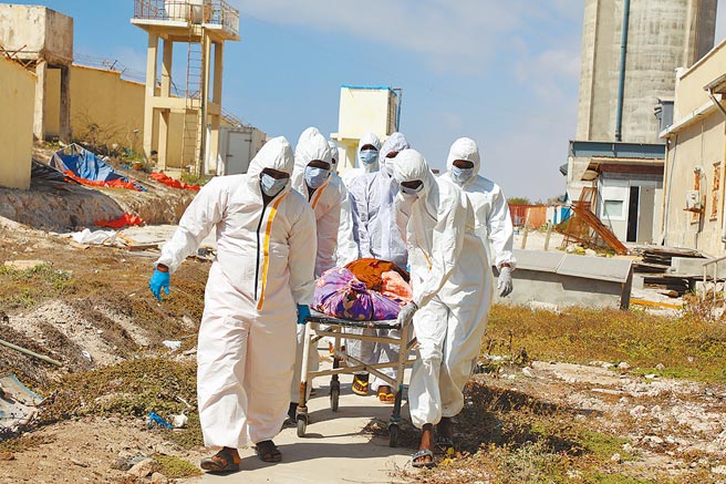 这是今年二月间，非洲索马利亚首都摩加迪休的医护人员正在搬运新冠肺炎病殁者的遗体。就在富裕国家有大量即将过期的新冠疫苗等着被抛弃的同时，许多穷国的民眾连第一剂疫苗都没得打。（新华社资料照片）