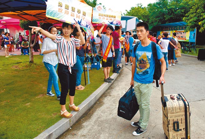 福州大學今年有119名新生放棄入學，近半數為台港學生。圖為福州大學一位迎新學姐（左前）在為學弟指路。（新華社）