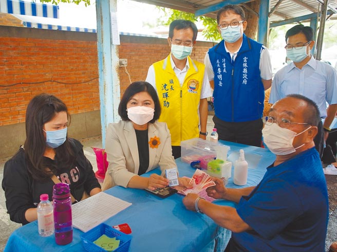 云林县五倍券消费10％现金回馈开跑，云林县长张丽善（左二）协助民眾兑领。（张朝欣摄）