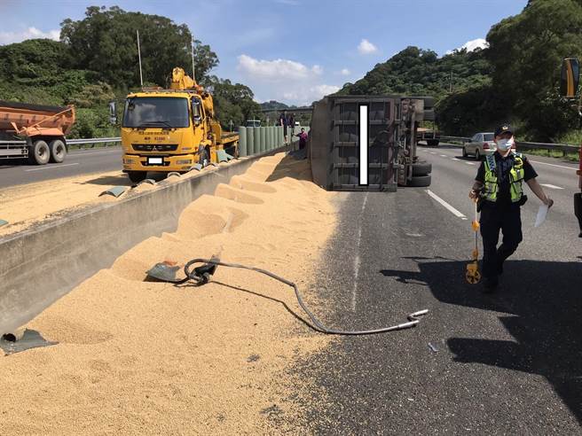 曾男驾驶的半联结车21日上午因为不明原因在国道10号东向18.1公里处翻车，车上黄豆洒满一地，还波及对向车道，造成另一女子驾驶自小客车因此打滑撞击内侧护栏。（翻摄照片／林瑞益高雄传真）