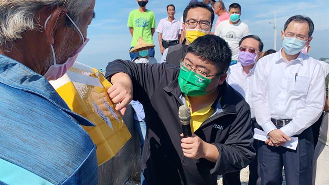 戴姓蚵农拿着保丽龙箱，指控有大陆蚵进到越南洗产地，再以越南蚵身分进到台湾，立委蔡易余仔细看上面的标籤。（吕妍庭摄）