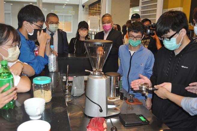 万钧旅行社行销部协理刘颖蒨（中）与展瑞旅行社总经理谢富兴(中左)，由醒吾科大旅运管理系系主任黄明一陪同，专注参观观餐学院学生调制咖啡上课情形。(戴志扬翻摄)