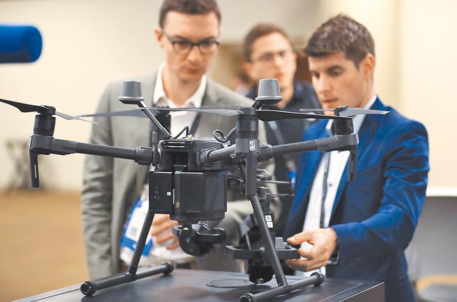 美国政府以国安为由，禁止联邦机构使用大疆创新的产品。图为在美国洛杉矶的一场展览会上，几名参观者正在检视大疆创新生产的一款无人机。（新华社）