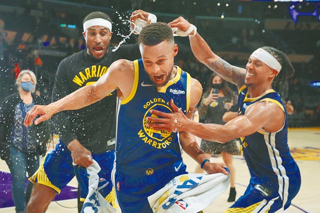 史提芬柯瑞（中）在开幕战勇士击退湖人后，被队友泼矿泉水庆祝。（路透）