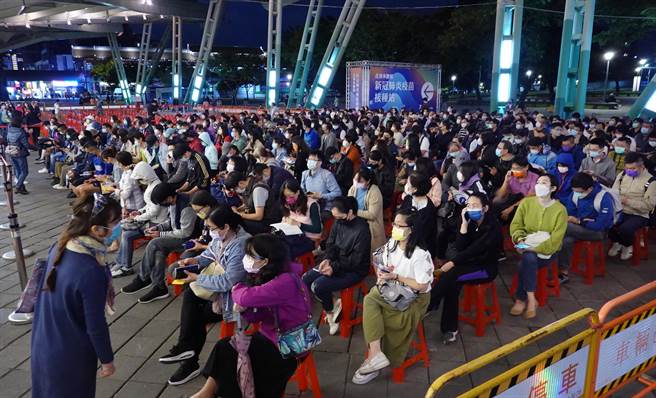 北市加大接種疫苗能量，花博疫苗接種站22日增加夜間施打時段，夜幕低垂時分，大批民眾在場外等候。（姚志平攝）