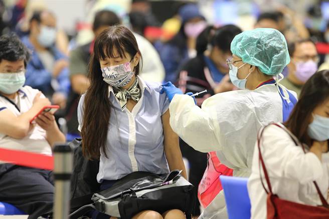 22日施打量能近乎全開，預計接種AZ疫苗1萬998人，有民眾在接種疫苗時露出不適神情。（杜宜諳攝）