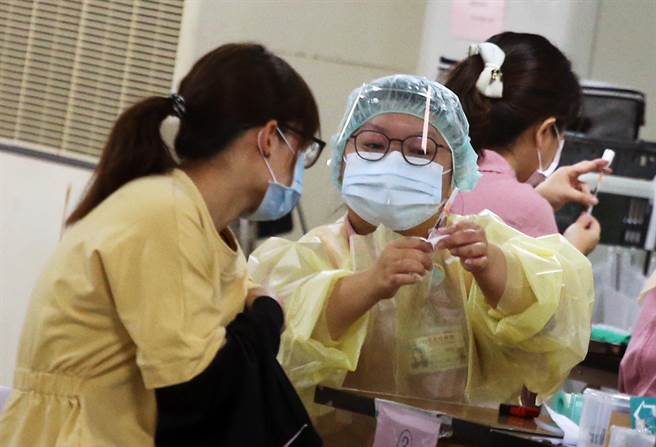 在台北市成德市場內的注射站，聯醫忠孝院區醫護人員為民眾施打BNT疫苗，由於分流得宜。（范揚光攝）