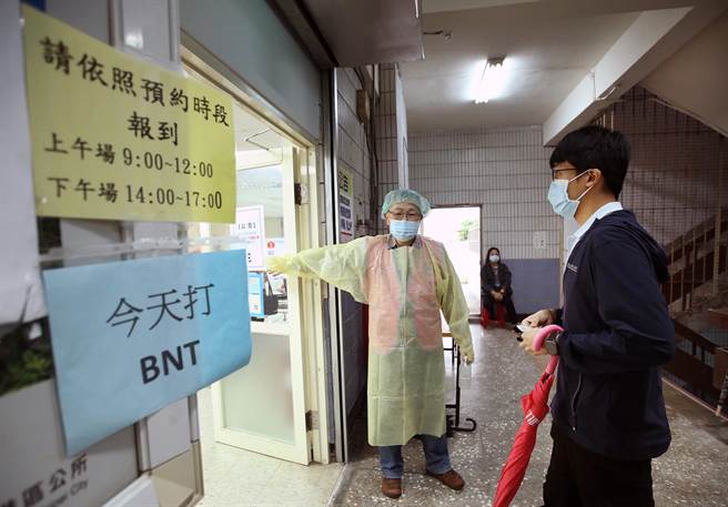 在台北市成德市場內的注射站，聯醫忠孝院區醫護人員為民眾施打BNT疫苗，扎針前護理人員再次確認疫苗種類。（范揚光攝）