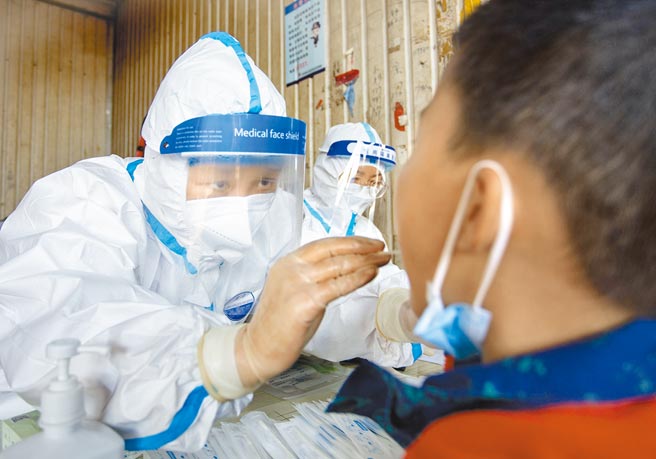 大陆此波本土疫情出现在陜西、寧夏、甘肃及内蒙古等「上海自驾旅行团」行迹之处，短短几日已新增湖南、北京、贵州、河北、湖北等9省市。图为21日兰州市一名学生正在做核酸检测。（中新社）