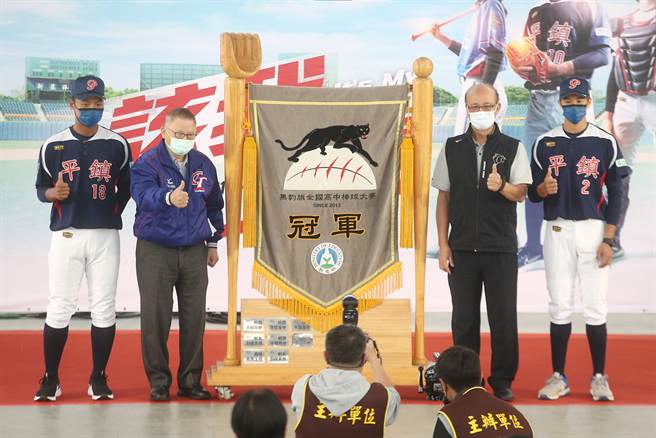 平镇高中球员代表伍佑城（左）、吕东翰（右）交还黑豹旗冠军锦旗。（杜宜谙摄）