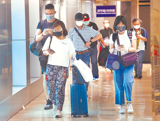 国内昨日新增2例本土个案及6例境外移入。图为桃园机场一群刚下机的旅客，忙着上网登录入境健康资料（图中非新闻当事人）。（范扬光摄）