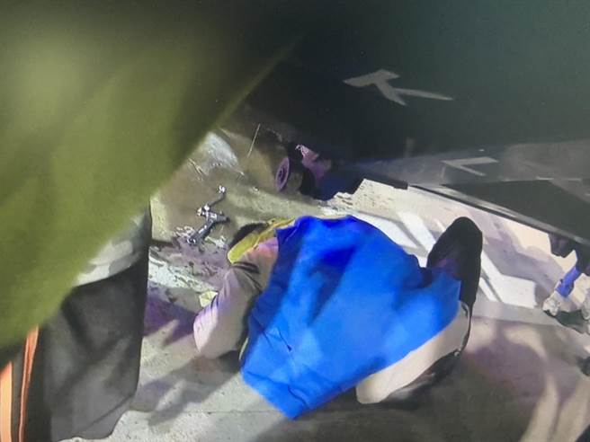货车驾驶自修大货车，惨遭百公斤升降车尾门重压，所幸龟山警和路人齐心撑起救出，捡回一命。(翻摄照片／蔡依珍桃园传真)