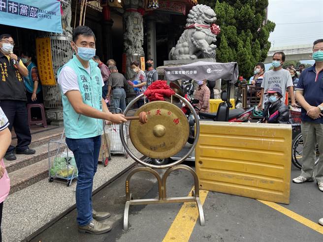 民眾党台中市党部代理主委张仲翘敲下爱心锣，与南天宫携手民眾党中彰投三个党部参与物资布施。（卢金足摄）