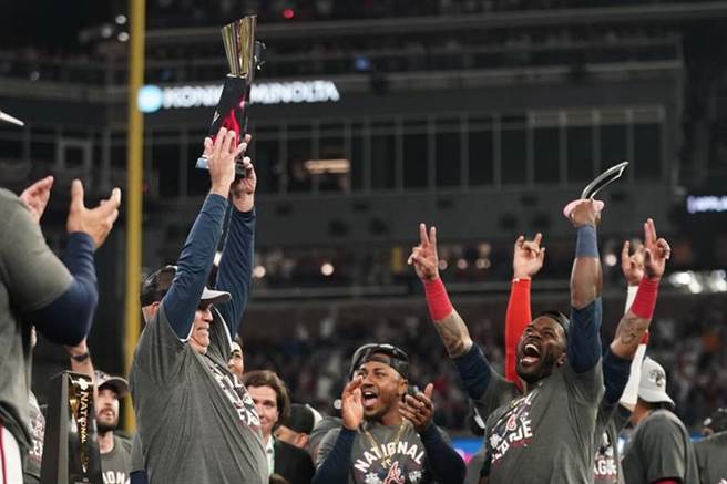 勇士队总教练史尼克高举国联冠军奖杯。（美联社）