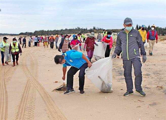 金门5乡镇公所今天在各辖区同步展开净滩活动，金寧乡长杨忠俊（中）带头捡拾垃圾。（李金生摄）