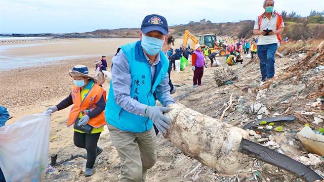 金湖镇长陈文顾在狗屿湾海滩，带头捡拾海漂垃圾。（金湖镇公所提供）