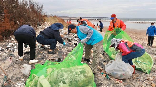 金湖镇长陈文顾在狗屿湾海滩，带头捡拾海漂垃圾。（金湖镇公所提供）