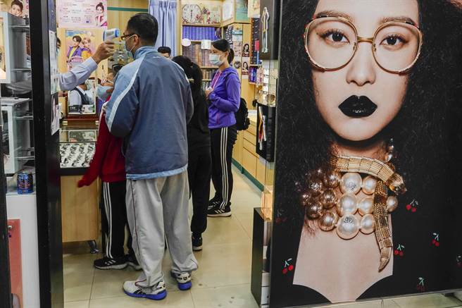 金門在微解封後當地經濟也顯得活絡，金城一家眼鏡行有許多顧客上門，店家仍不忘對客人實施量體溫等防疫措施。（黃子明攝）