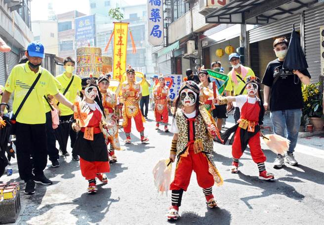 由学童组成的阵头五毒大神，仅在东港迎王期间限定出阵，所到之处皆吸引信徒围观。（林和生摄）