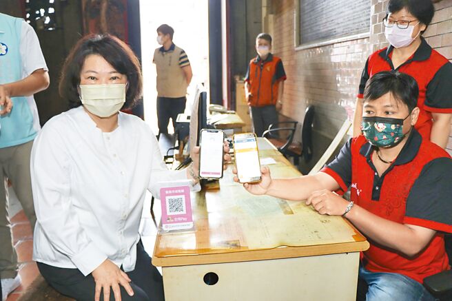 嘉义市长黄敏惠（左）24日前往嘉义市城隍庙用电子支付为母亲点光明灯。（嘉义市政府提供／张亦惠嘉县传真）