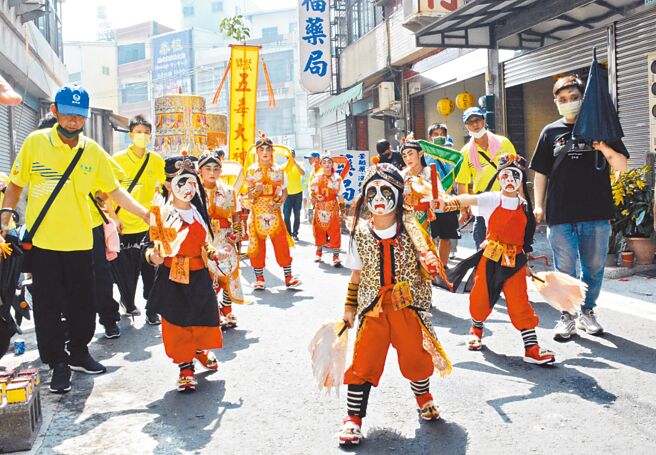 由学童组成的阵头五毒大神，仅在东港迎王期间限定出阵，所到之处皆吸引信徒围观。（林和生摄）