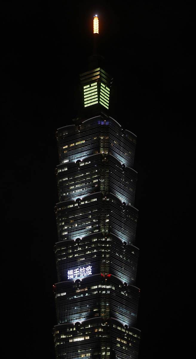 日本捐赠第6批约30万剂AZ疫苗27日运抵台湾，台北101于晚间6时30分起点灯打出「暖心互助」、「携手抗疫」等字样，感谢日本温暖深厚的友谊。（刘宗龙摄）