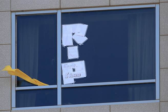 住在华航诺富特饭店检疫的机师，在窗外挂上黄飘带，还有机师特别用白纸条拼成「RIP」字样，上面还写着「CDC KILLS PILOTS」。（陈麒全摄）