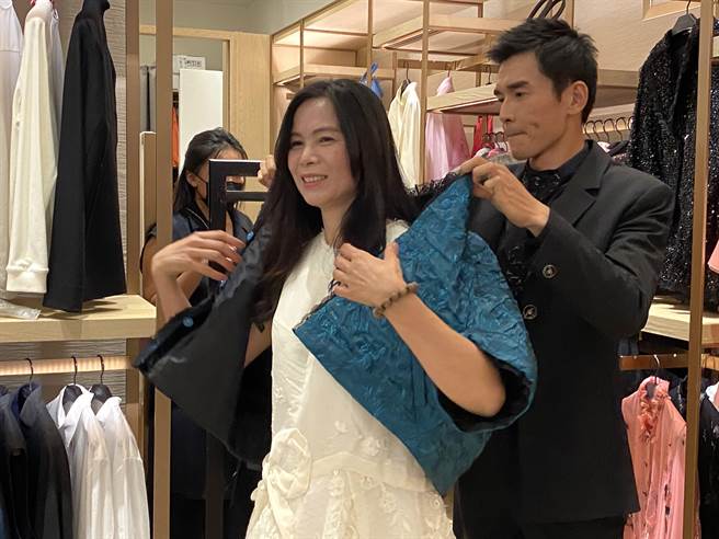 杨一展当一日店长，替客人试穿衣服，当称职店长。（廖素慧摄）