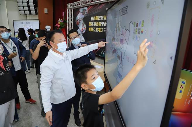 翁章梁亲自体验电子白板功能，白板上显示嘉义县行政区域图，限时内正确填上各乡镇名称即获胜，安东国小学童与翁章梁合作，1分钟内全数答对。（嘉义县政府提供∕吕妍庭嘉义传真）