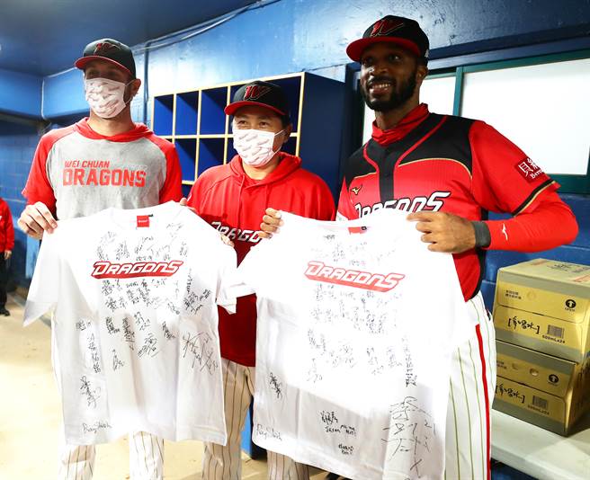 味全龍的洋將鋼龍（左）與赫雷拉（右）結束28日的例行賽後即將離隊返國，總教練葉君璋（中）特別贈送全隊的簽名球已給予祝福。（季志翔攝）
