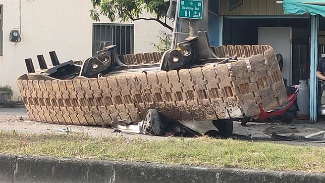 一具10吨重履带突滚落载运的曳引车，路旁停放轿车瞬间压成铁饼。(翻摄自记者爆料网）