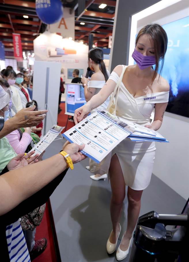 参展厂商请来辣妹促销商品，发送纪念品给民眾拉高买气。（郑任南摄）