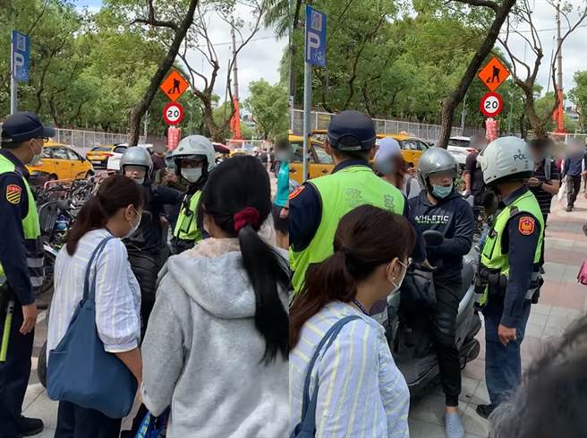 高姓男骑士违规将车骑上人行道，还对警察叫嚣，引起路人围观。（翻摄自脸书社团《爆料公社公开版》）