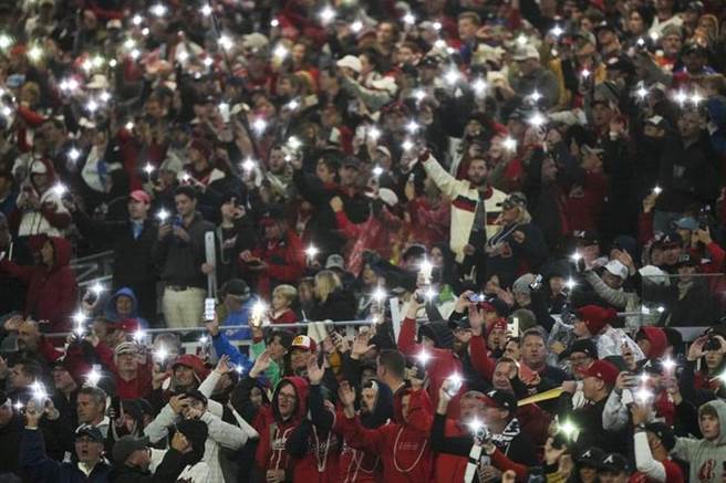 勇士隊主場球迷點亮手機一起跳戰斧舞。（美聯社）