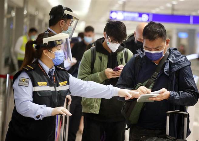 在桃園機場入境管制區內，防疫人員協助旅客上網登錄入境健康資料。（范揚光攝）（圖中非新聞當事人）
