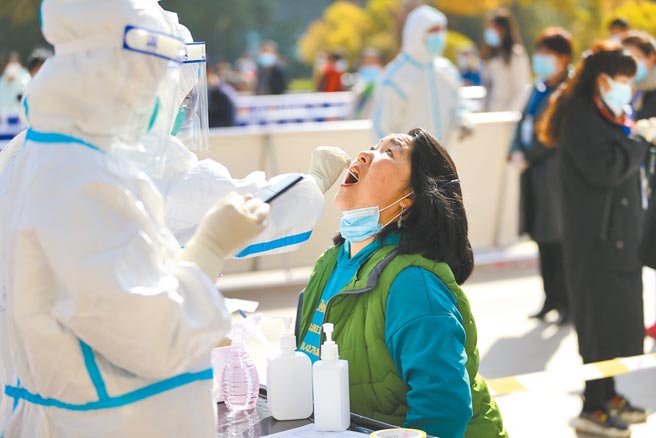 大陸防疫專家張文宏指出，未來即便全世界都打上疫苗，到室內仍要盡量戴口罩。圖為29日青海省海東市平安區在做全員核酸檢測。（中新社）