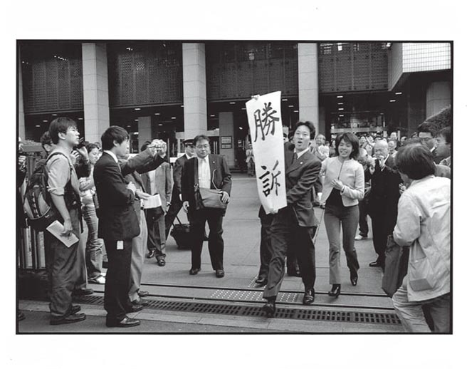 原告律師濱野泰嘉奔出「東京地方法院」大門外，揭開「勝訴」兩大字的瞬間，四周隨之響起歡呼聲，這人權史上的一大步，當天的晚報及翌日各大報都以頭條新聞傳播出去。⊙攝影／張蒼松