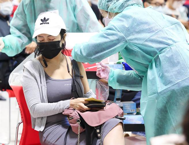 国内疫情趋缓，为提升疫苗覆盖率，1日花博疫苗接种站，替预约接种第二剂AZ民眾施打疫苗，有民眾打疫苗时疼痛紧闭双眼。(陈俊吉摄)