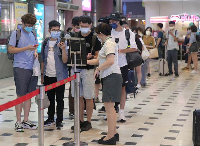 图为台北转运站的候车月台，乘客拿手机完成实联制准备上车。(资料照/粘耿豪摄)